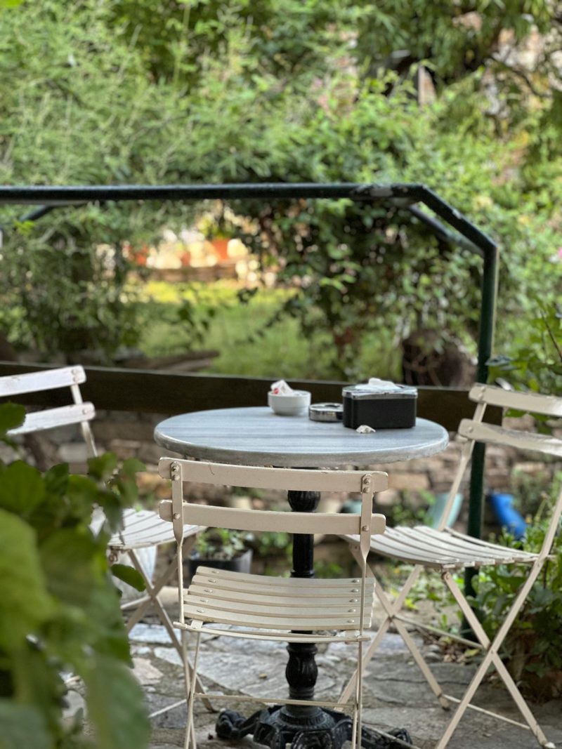 A small bistro table surrounded by garden planting