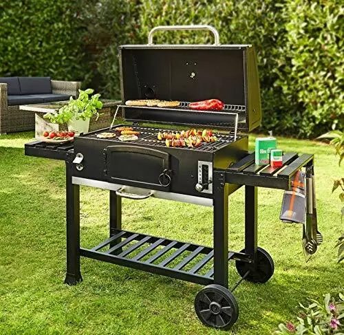 A black charcoal barbecue trolley on a lawn