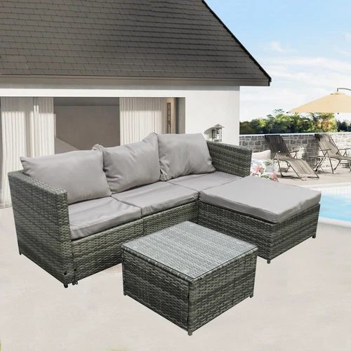 A grey rattan corner sofa set with a table